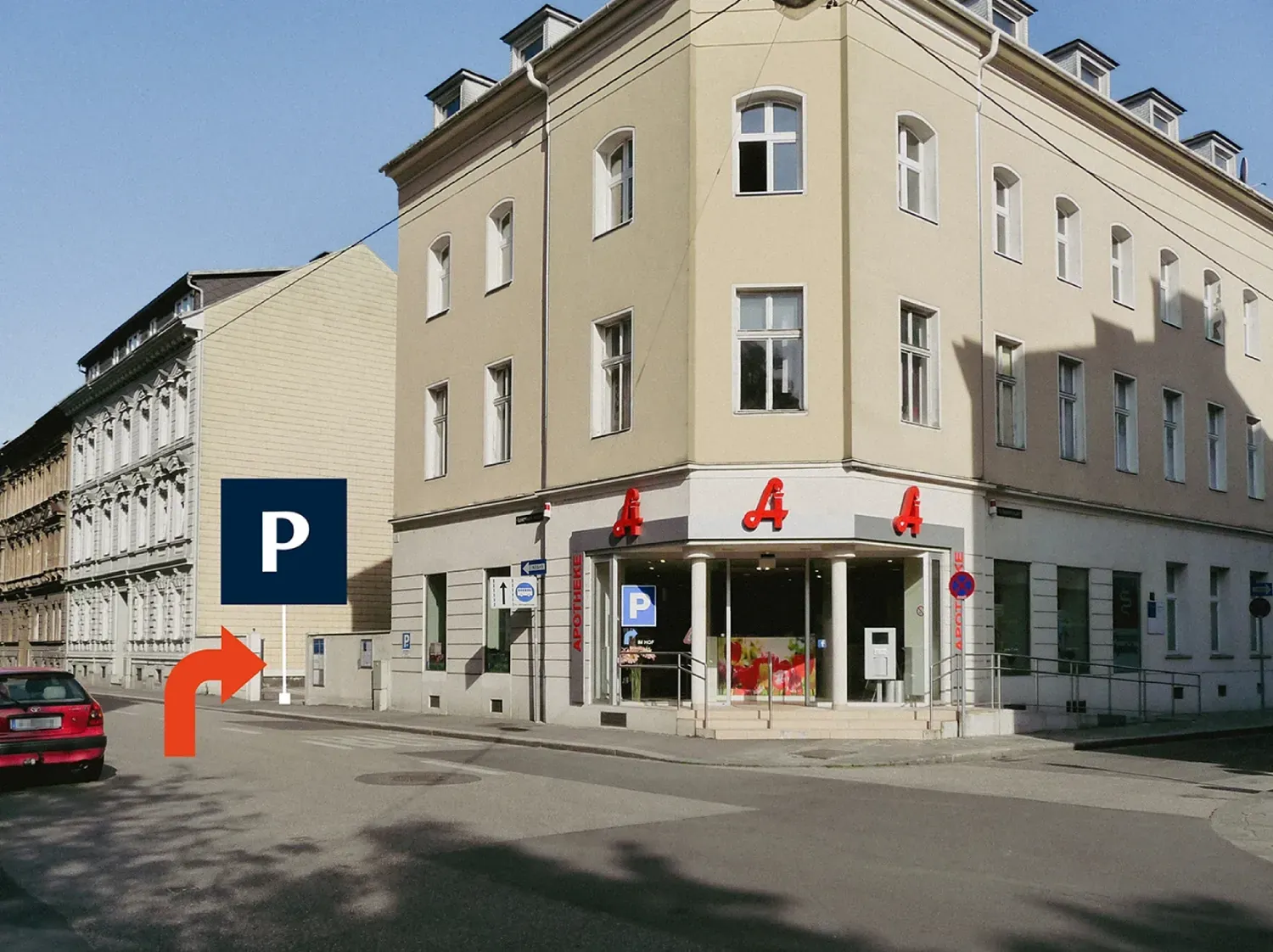 Eckhaus Schubertstraße/Lustenauerstraße mit der Hessenplatz-Apotheke im Erdgeschoß, Hinweis auf die Zufahrt zu den Parkplätzen im Hof