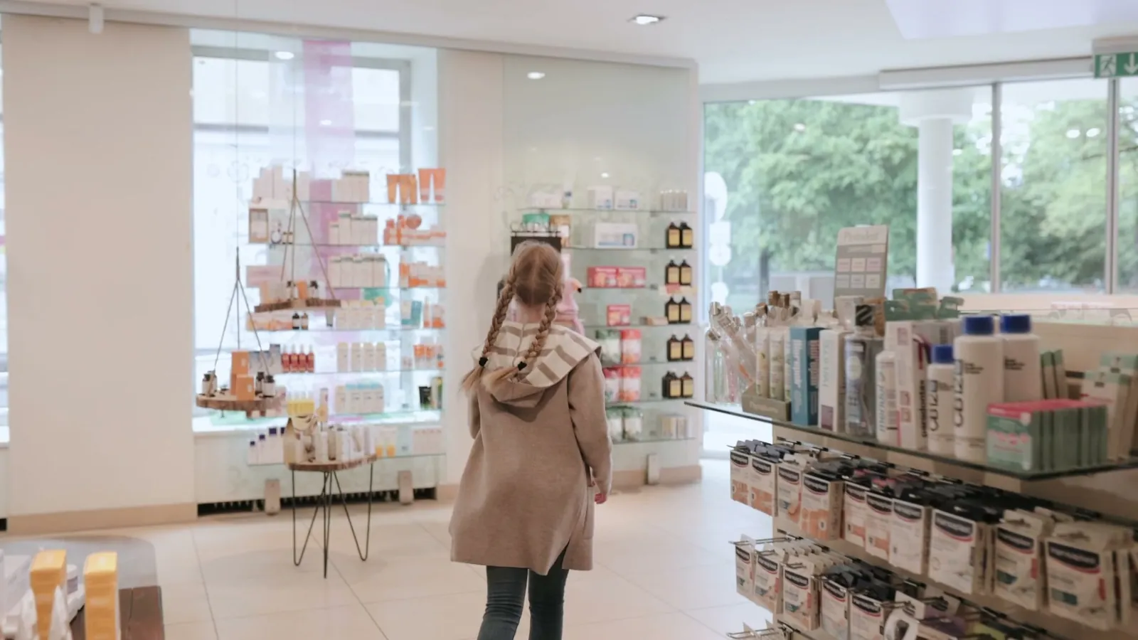 Heller Verkaufsraum der Hessenplatz-Apotheke mit großen Fenstern und Regalen voller Pflegeprodukte
